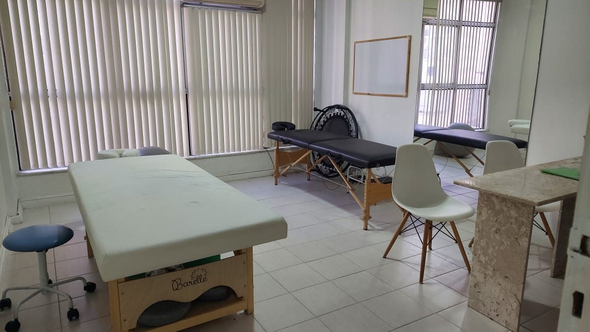 Sala de atendimento com macas e janelas amplas