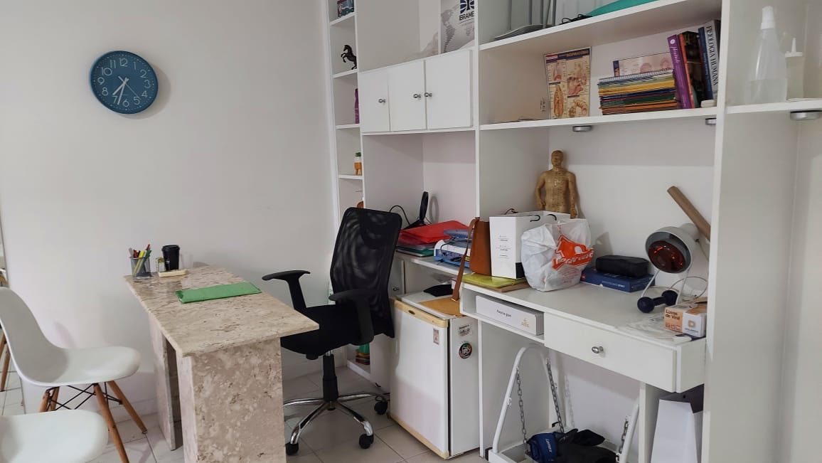 Mesa de atendimento e estantes do consultório