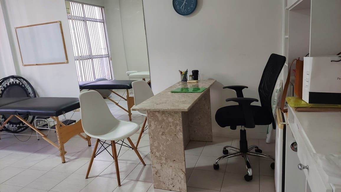 Consultório com mesa e maca